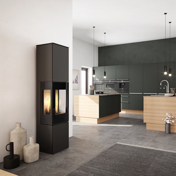 Stufa a gas NEXO 185 in nero con porta del focolare in vetro e due finestre laterali al centro della cucina e del soggiorno