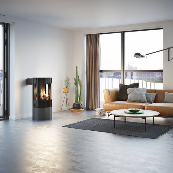 Stufa a gas VIVA 100 L in platino con porta del focolare in vetro in un appartamento minimalista con vista sullo skyline