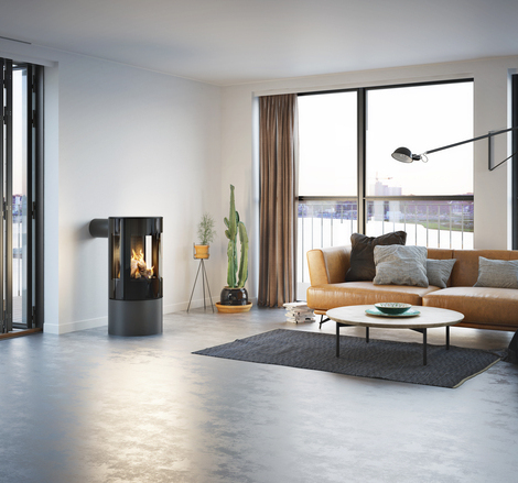 VIVA 100 L GAZ en platine avec porte de foyer plein verre Poêle à gaz VIVA 100 L en platine avec porte de foyer plein verre dans un appartement minimaliste avec vue sur le skyline