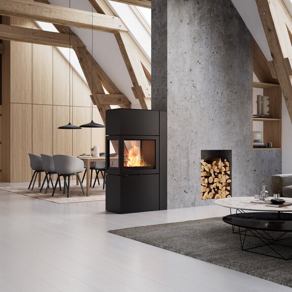 600 RD stove in black in a light and modern living room with wooden elements and a concrete wall
