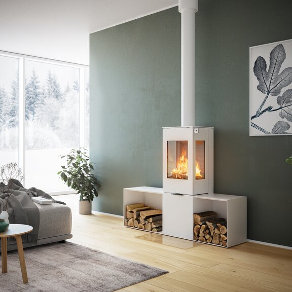 Stufa a legna NEXO 120 in bianco con porta in acciaio, due finestre laterali e due panca laterale davanti a una parete verde in un soggiorno decorativo