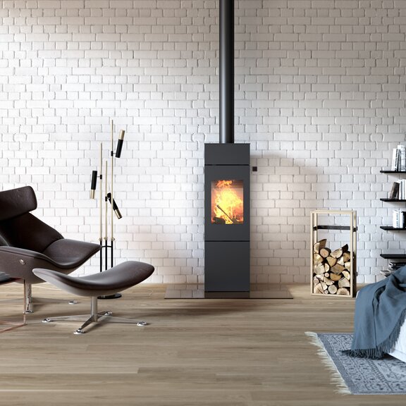 Stufa a legna NEXO 140 in nero con porta in acciaio in un loft in stile industriale con grande libreria