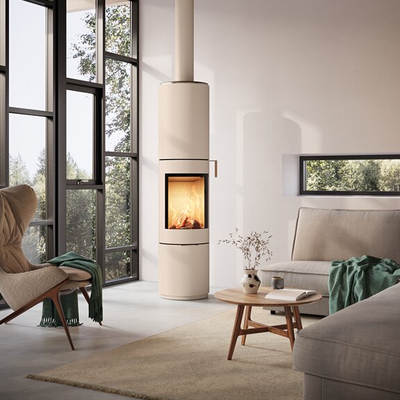 Stufa a legna PILAR in sabbia con porta in acciaio e maniglia in rovere in un soggiorno moderno con grande finestra frontale