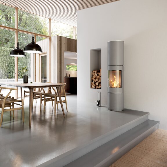 Stufa a legna PILAR in nichel con porta in acciaio e maniglia in acciaio inox nella sala da pranzo con stile di arredamento moderno