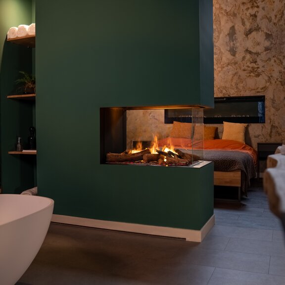 Cheminée électrique e-Matrix Mood 800/500 séparateur de pièce dans une chambre d'hôtel avec lit et baignoire sur pied