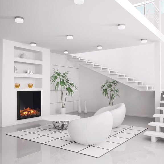 Feu électrique Juneau dans le salon blanc avec escalier et meubles blancs