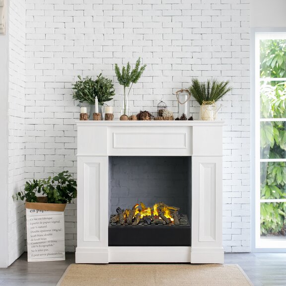 Feu électrique Juneau dans le salon avec mur blanc en pierre de Bach encastré dans un habillage de cheminée blanc