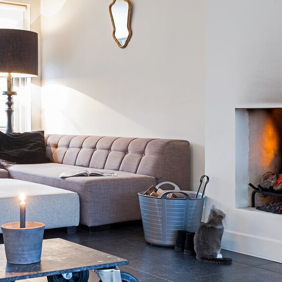 Feu électrique Silverton avec support en bois dans un salon confortable avec canapé et chat