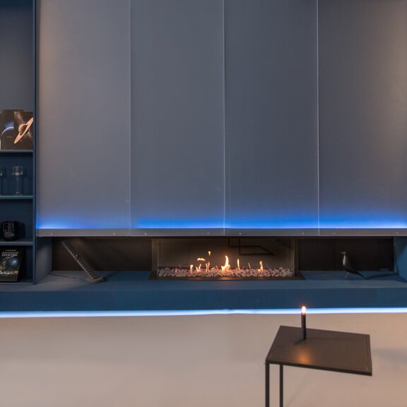 Camino a gas MatriX Linear 1300/400 a tre lati di Faber nel soggiorno con illuminazione blu