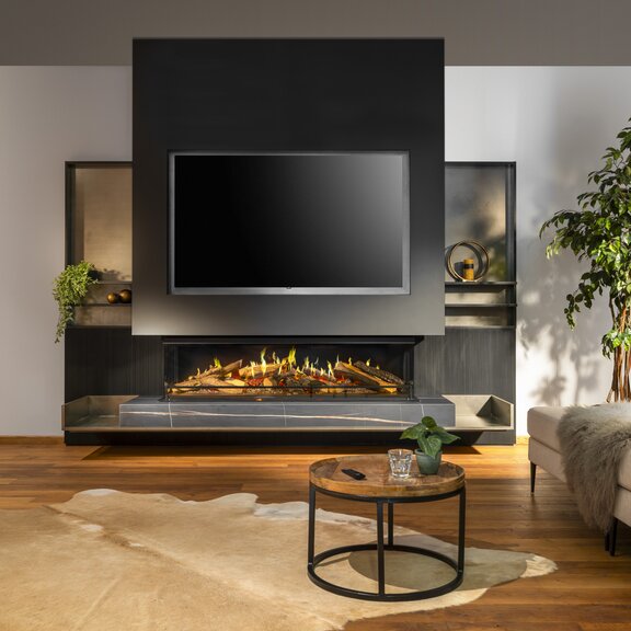 Foyer électrique tri-face E-One 160 S dans un salon moderne avec canapé et tapis.