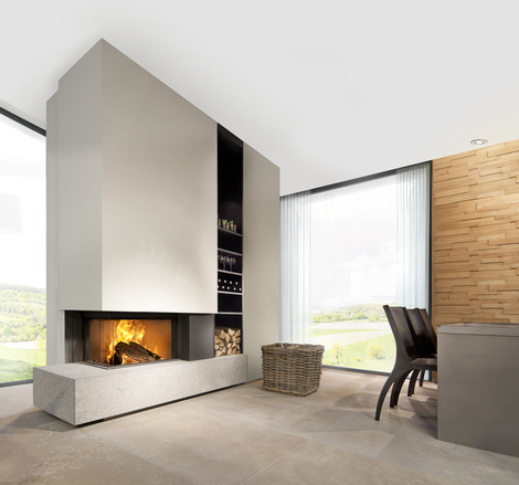 W65/38C von Kalfire - Eckkamin links Holz-Kamin W65/38C von Kalfire. Der zweiseitige Kamin (links) ist in einer beigefarbenen Zwischenwand eingebaut und steht auf einer modernen Bank aus Naturstein